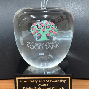 2025 Hospitality & Stewardship Award from the RI Food Bank, featuring a crystal apple on a plaque